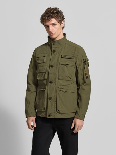 Męski model nosi Jacke mit Stehkragen und Cargotaschen Modell 'CARGOYET' od PME Legend, zielona, krój regular fit, kieszenie cargo, całkowity widok z przodu. Szerokość w rozmiarze M: 58 cm, długość tyłu: 72 cm, szerokość ramion: 47 cm, długość rękawa: 67 cm.