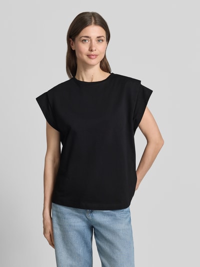 Modelka kobieca nosi T-Shirt z drapowaniami model 'PIO' od Bash, czarna bawełna, krój regular fit, okrągły dekolt, widok całej sylwetki z przodu.