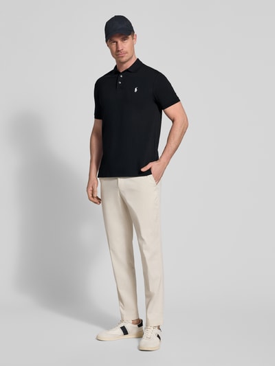 Männermodel trägt Slim Fit Poloshirt aus Baumwoll-Mix von Polo Ralph Lauren, Optik: Unifarben, Logo-Detail, Polokragen, Piqué, Ganzkörperansicht von vorne.