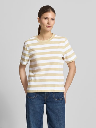 Kobiece model nosi damski t-shirt Boxy Fit T-Shirt aus reiner Baumwolle Modell 'ESSENTIAL' od Selected Femme, efekt: wzór w paski na całej powierzchni, pudełkowy krój, okrągły dekolt, krótki rękaw, wykończenie materiału: heavy dżersej, 100% bawełna, naszywka z logo, odcień beżowo-biały, widok całej sylwetki z przodu.