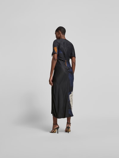 Frauenmodel trägt Slim Fit Maxikleid aus reiner Viskose von Victoria Beckham mit floraler Allover-Print, Rundhalsausschnitt, kurzärmelig, in dunklen Farben mit blauen und beigen Details, feine glatte Textur, Gesamtlänge 142 cm, Brustweite 40 cm, Ärmellänge 27 cm, Ganzkörperansicht Rückansicht.