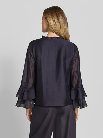 Frauenmodel trägt Regular Fit Bluse aus Lyocell-Mix mit Volants von Comma in dunklem Blau, transparente Ärmel, Rückenlänge 58 cm, Ganzkörperansicht Rückansicht.