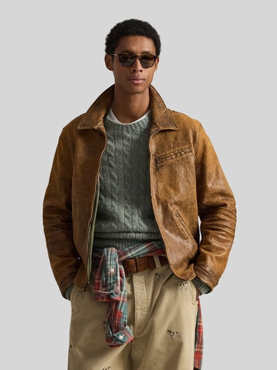 Męski model nosi Regular Fit Bomberjacke aus Schafsleder von Polo Ralph Lauren w stylu used look, brązowa faktura skóry, widok na cały górny korpus z przodu.