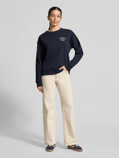 Frauenmodel trägt Sweatshirt mit Label-Stitching und Rundhalsausschnitt von Gant in Dunkelblau, Baumwolle, Loose Fit, Ganzkörperansicht von vorne.