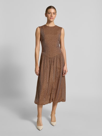 Vrouwenmodel draagt Bubble Kleid met Rundhalsausschnitt Modell 'KRISSI' van YAS, bruin met wit stippenpatroon, getailleerde fit, materiaal-mix met lyocell, midijurk, rugzijde rits, voorkant volledige lichaamsweergave.