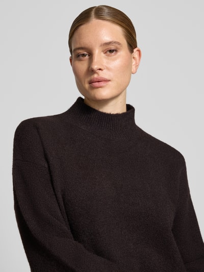 Frauenmodel trägt Turtleneck-Pullover mit Woll-Anteil und Rundhalsausschnitt von Neo Noir in dunkler Farbe, Struktur fein gestrickt, Nahaufnahme Oberkörper.