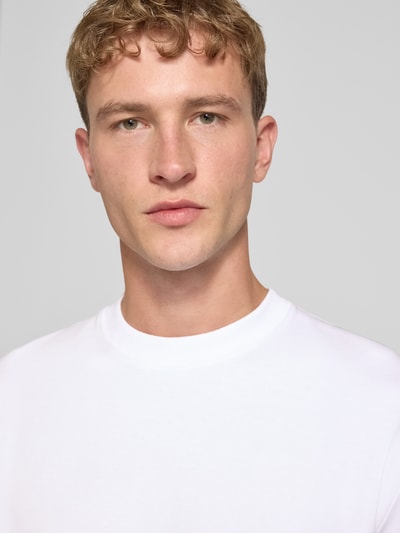 Männermodel trägt Relaxed Fit T-Shirt aus elastischem Baumwoll-Mix Modell 'SCUBA' von JACK & JONES, weiß, Nahaufnahme Oberkörper. Rückenlänge bei Größe M: 68 cm, Rundhalsausschnitt.