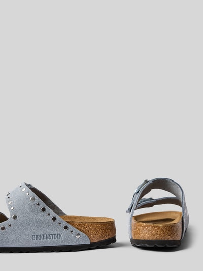 Produktfoto, Hausschuhe aus echtem Leder Modell 'Arizona' von Birkenstock mit abgerundeter Passform, Nietenbesatz, Strukturmuster, offene Ferse, Absatzhöhe 3 cm bei Größe 40, graue und braune Farbtöne, seitliche und Rückansicht.