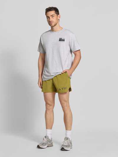 Männermodel trägt Shorts mit elastischem Bund von HALO in Olivgrün, Regular Fit, Label-Print, Material-Mix, Ganzkörperansicht von vorne.