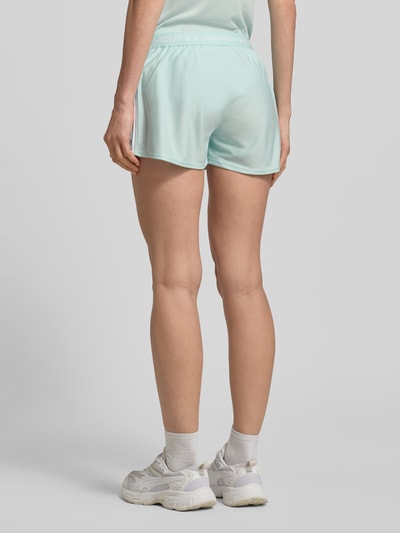 Frauenmodel trägt Shorts mit elastischem Bund und Logo von Under Armour in Mintgrün mit Label-Details, Regular-Fit, Bundweite 39 cm, Innenbeinlänge 8 cm, Ganzkörperansicht Rückansicht.