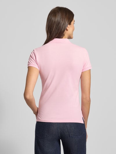 Frauenmodel trägt Slim Fit Poloshirt mit Logo-Stitching Modell 'JULIE' von Polo Ralph Lauren aus Baumwoll-Elasthan-Mix, unifarbenes Design, Polokragen, kurze Knopfleiste, gerippte Ärmelabschlüsse, Rückenlänge bei Größe S 65 cm, Ganzkörperansicht Rückansicht.
