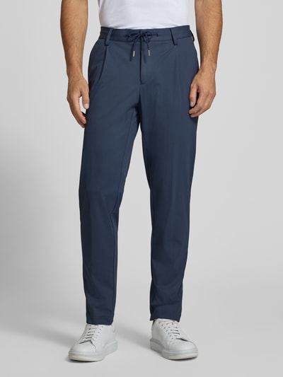 Männermodel trägt Regular Fit Hose mit Tunnelzug und Eingrifftaschen von bugatti, Material-Mix mit Stretch, Ganzkörperansicht von vorne.