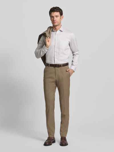 Männermodel trägt Regular Fit Anzughose mit Viskose-Anteil von s.Oliver BLACK LABEL in Optik: Unifarben, Melange, Materialverarbeitung: Chambray, mit Knopf-Reißverschluss, Label-Stitching, Gürtelschlaufen, Bügelfalten sowie seitlichen Eingrifftaschen und Gesäßtaschen, Ganzkörperansicht von vorne.