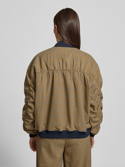 Frauenmodel trägt Loose Fit Bomberjacke mit Knopfleiste Modell 'chicca' von Gestuz, kariertes Muster, elastische Abschlüsse, Ganzkörperansicht Rückansicht. Rückenlänge 56 cm, Schulterbreite 44 cm, Brustweite 58 cm, Ärmellänge 52 cm.