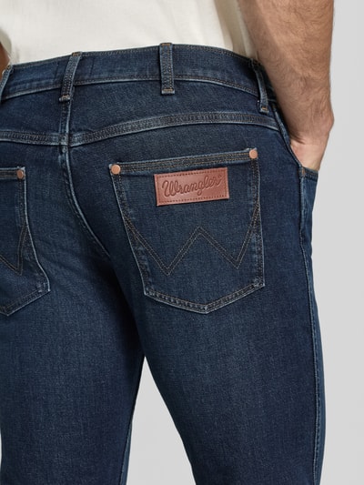 Männermodel trägt Straight Fit Jeans aus Baumwoll-Mix Modell 'Greensboro' von Wrangler in Dunkelblau, Detailaufnahme, Herren Straight Fit Jeans von Wrangler.