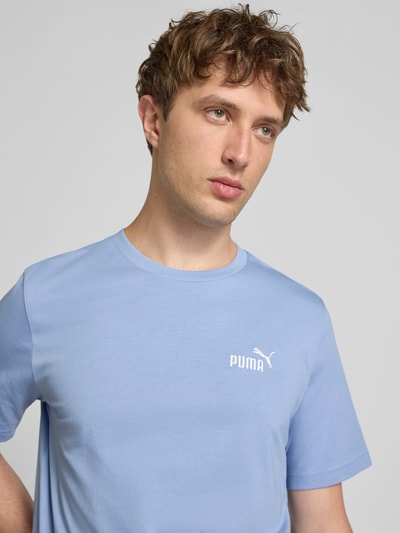 Männermodel trägt Regular Fit T-Shirt mit Logo-Stitching van PUMA PERFORMANCE in lichtblauw, katoenen stof, ronde hals, Nahaufnahme Oberkörper.