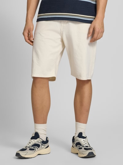 Männermodel trägt Baggy Fit Jeansshorts Modell 'ALEX' von Jack & Jones aus reiner Baumwolle in Beige mit Eingrifftaschen, Ganzkörperansicht von vorne.