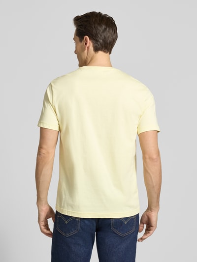 Männermodel trägt Regular Fit T-Shirt mit Logo-Stitching von Gant in Gelb, reine Baumwolle, Rundhalsausschnitt, Ganzkörperansicht Rückansicht.