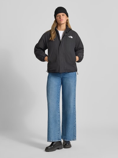 Frauenmodel trägt Jacke mit Wendefunktion Modell 'YUMIORI' von The North Face in Schwarz, Regular Fit, Logo, Ganzkörperansicht von vorne. Rückenlänge 62 cm, Schulterbreite 52 cm, Brustweite 57 cm, Ärmellänge 57 cm.