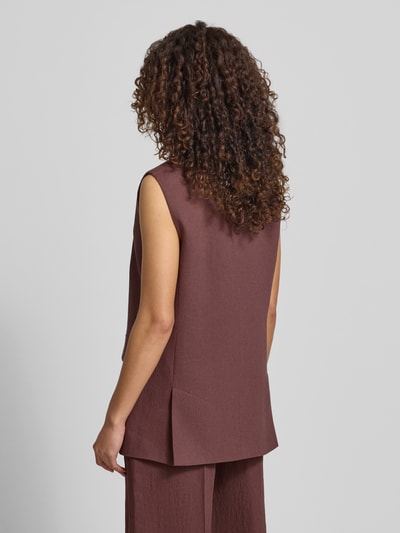 Vrouwenmodel draagt Regular Fit bodywarmer uit mix van linnen en viscose model 'JANKANIA' van BOSS in melangelook, rompzoom met zijsplitten, twill materiaalverwerking, klepzakken, reverskraag, 1-knoopssluiting, gemêleerde structuur, kleur: bruinrood, detailopname van achteren.