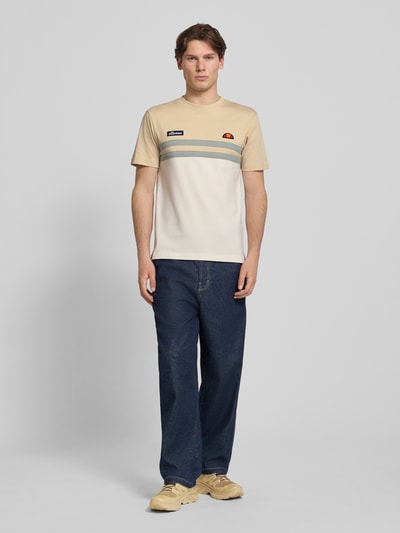 Męski model nosi T-Shirt mit Label-Stitchings und Rundhalsausschnitt od ellesse z bawełny, krój regular fit, długość tyłu 69 cm, widok z przodu, cała sylwetka.