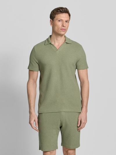 Männermodel trägt Regular Fit Poloshirt aus Baumwoll-Mix von MCNEAL in Olivgrün, Waffle-Piqueé, Umlegekragen, Kurzärmelig, Ganzkörperansicht von vorne.