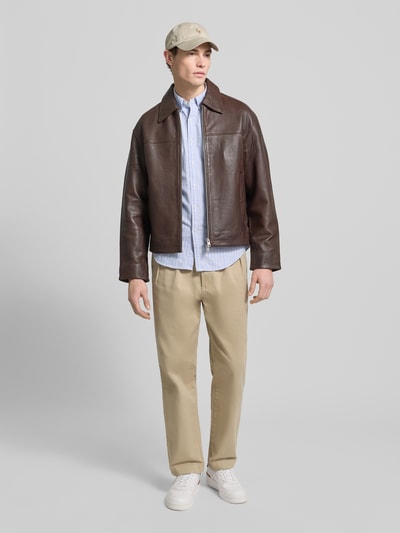 Mannenmodel draagt 'Slim Fit Freizeithemd met Knopfleiste' van Polo Ralph Lauren in lichtblauw met strepen, puur katoen, slim fit, button-downkraag, knoopsluiting, labelstitching; ruglengte maat M 78 cm, schouderbreedte 44 cm, mouwlengte 66 cm. Ganzichaansicht van voren.