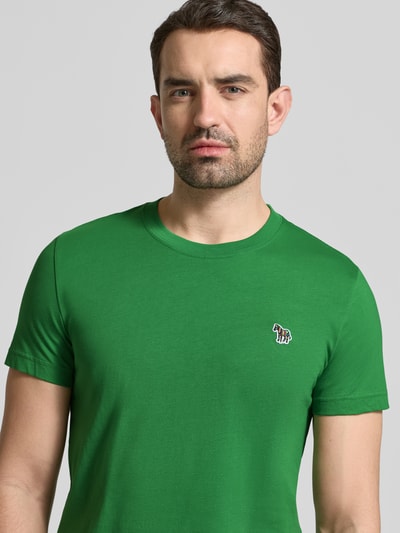 Männermodel trägt Slim Fit T-Shirt mit Rundhalsausschnitt von PAUL SMITH in kräftigem Grün, reine Baumwolle, Nahaufnahme Oberkörper.