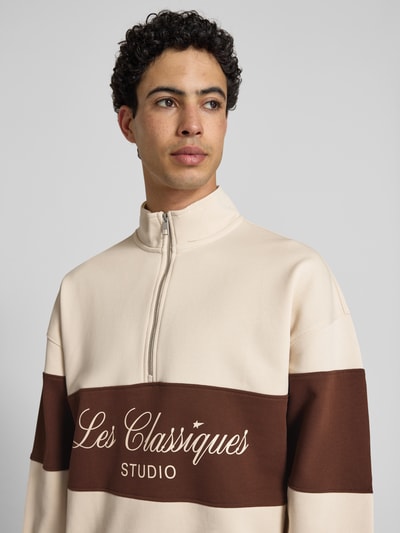 Männermodel trägt Oversized Troyer aus reiner Baumwolle Modell 'LES CLASSIQUES' von Only & Sons in Two-Tone-Optik mit Schriftzug und Label-Patch, Sweat-Material, Nahaufnahme Oberkörper.