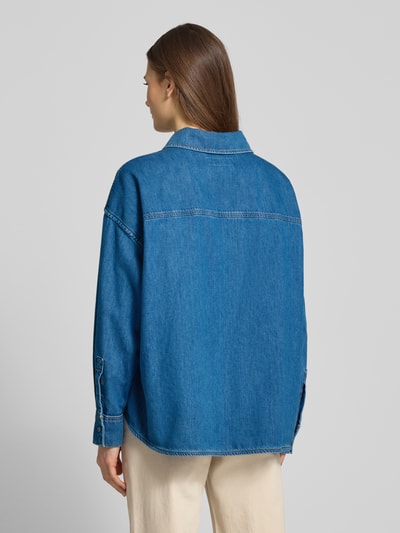 Frauenmodel trägt Relaxed Fit Jeansbluse aus reiner Baumwolle Modell 'FOGGIA' von Weekend Max Mara in klassischem Denim mit Kontrastnähten, Rückenansicht.