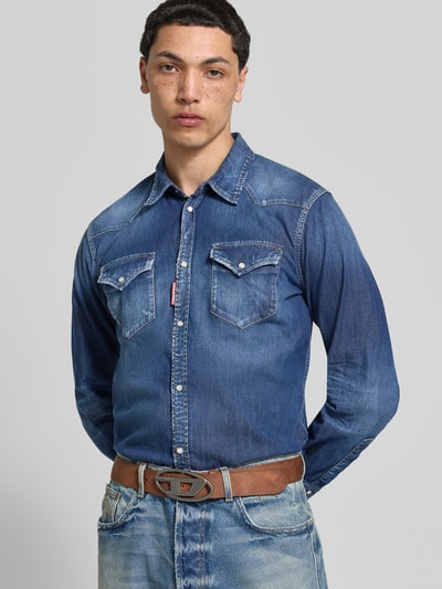 Männermodel trägt Ledergürtel aus echtem Leder von Diesel in Braun mit Pinschließe, Label-Detail und Used-Look, klassische Passform, Nahaufnahme Oberkörper.