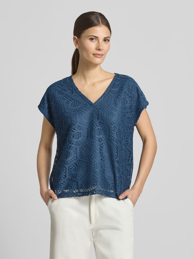 Modelka kobieca ma na sobie damski t-shirt Boxy Fit T-Shirt mit semitransparentem Besatz Modell 'IRIS' od Vero Moda, efekt: jednolity kolor, wzór: abstrakcyjny, półprzezroczysty materiał, dekolt w serek, bez rękawów, wykończenie materiału: ażur, krój stretch; całe ciało widoczne od przodu