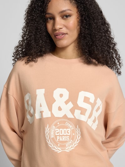 Frauenmodel trägt Sweatshirt mit Label-Print Modell 'BENJAMIN' von Bash aus Baumwoll-Elasthan-Mix, Relaxed-Fit, Rundhalsausschnitt, Nahaufnahme Oberkörper.