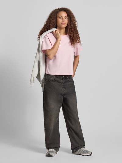 Frauenmodel trägt kurzärmeliges Sweatshirt mit Stickerei von REVIEW in Rosa, Baumwoll-Mix, relaxed Fit, 1/2-Arm, Ganzkörperansicht von vorne.