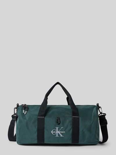 Produktfoto, Weekender met Labelstitching van CK Calvin Klein in donkergroen met zwarte draagbanden, hoofvak met ritssluiting, afneembare schouderband, binnenvak met ritssluiting, breedte 45 cm, lengte 24 cm, diepte 22 cm, schouderriemlengte 90 cm.