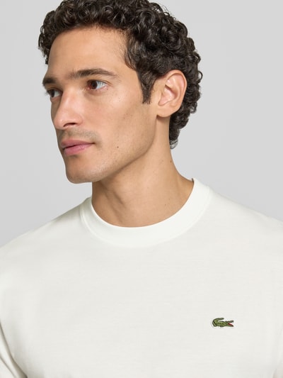 Männermodel trägt Regular Fit T-Shirt aus reiner Baumwolle von Lacoste, weiß, glatter Stoff, Nahaufnahme Oberkörper, Herren T-Shirt von Lacoste.