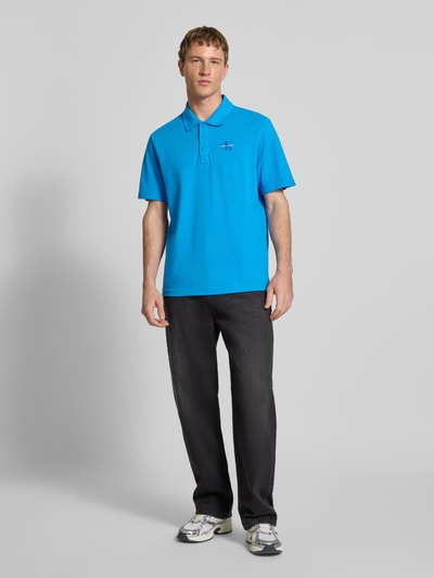 Männermodel trägt Easy Fit Poloshirt mit Polokragen von Calvin Klein Jeans, Reine Baumwolle, Label-Stitching, Ganzkörperansicht von vorne.