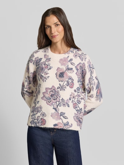 Vrouwenmodel draagt Relaxed Fit Strickpullover mit Leinen-Anteil van Christian Berg Woman, elastische materiaalmix met linnen, ribboorden, bies, lange mouw, ruglengte maat S 57 cm, mouwlengte maat S 62 cm, gebroken wit met paarse/roze bloemenmotief, geribde textuur, gebreide look, Ganzkörperansicht van voren.