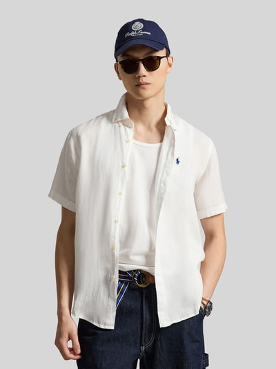 Mannelijk model draagt Regular Fit Leinenhemd mit Button-Down-Kragen van Polo Ralph Lauren in effen wit, kortemouw van puur linnen, voorkant borstlogo, volledig knopenlijst, met afgeronde zoom. Ganzkörperansicht van voren.