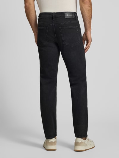 Männermodel trägt Straight Fit Jeans aus Baumwoll-Mix Modell 'Ogden' von BOSS in dunklem Grau, strukturierte Oberfläche, Ganzkörperansicht Rückansicht, Herren Slim Fit Jeans von BOSS.