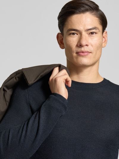 Mannelijk model draagt Strickpullover aus Wollmix Modell 'Bennino' van JOOP! collectie, look: effen, gebreide look, ronde hals, mouwvorm: lange mouw, mouwboord, rompzoom: geribd, detailopname bovenlichaam.