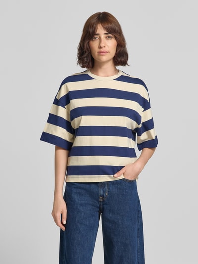 Frauenmodel trägt Oversized T-Shirt aus reiner Baumwolle von s.Oliver RED LABEL, Streifenmuster in Dunkelblau und Creme, lockere Passform, Ganzkörperansicht von vorne.
