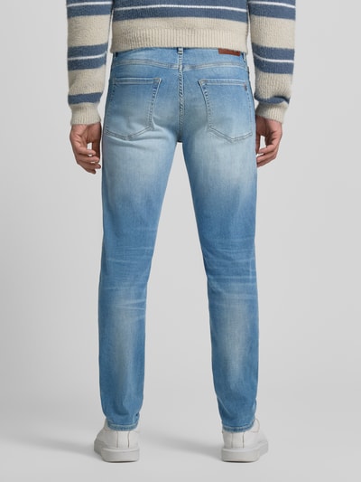 Männermodel trägt Slim Fit Jeans aus Baumwoll-Mix Modell 'ONYX' von BOSS Orange, hellblauer Denim, Label Patch, Ganzkörperansicht Rückansicht.