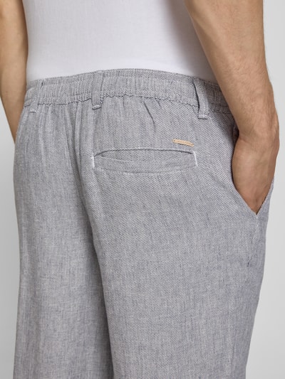 Mannenmodel draagt Leinenhose mit Bindegürtel Modell 'KARL MYKONOS' van Jack & Jones, mix van linnen en viscose, relaxed fit, strookzak aan de achterkant, steekzak, fijne grijze structuur, bandwijdte maat M 41 cm, binnenbeenlengte maat M 78 cm, detailopname rechterzij.