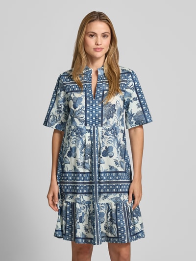 Frauenmodel trägt Knielanges Tunikakleid mit 1/2-Arm von Christian Berg Woman, floraler Print in Blau und Weiß, Reine Baumwolle, Straight Fit, Tunikakragen, Knielänge, Ganzkörperansicht von vorne.