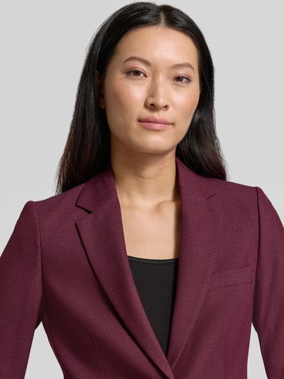 Frauenmodel trägt Regular Fit Blazer aus Viskose-Mix von Christian Berg Woman Selection in dunklem Bordeauxrot mit Reverskragen, Nahaufnahme Oberkörper.