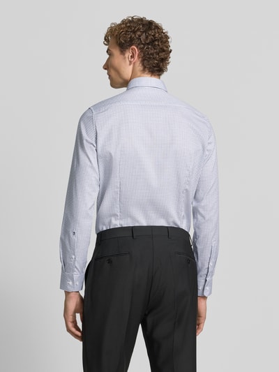Männermodel trägt Slim Fit Businesshemd aus reiner Baumwolle Modell 'New B.D.' von Seidensticker, feines Karo-Muster, Ganzkörperansicht Rückansicht, Herren Businesshemd von Seidensticker.