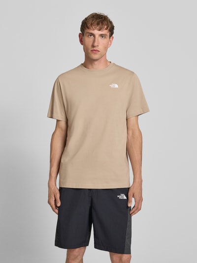 Männermodel trägt T-Shirt mit Label-Stitching und Rundhalsausschnitt von The North Face aus Baumwoll-Mix in Regular-Fit, Ganzkörperansicht von vorne. Rückenlänge bei Größe M: 72 cm.