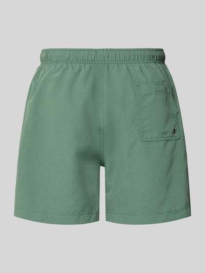 Produktfoto, spodenki kąpielowe 'Badehose mit Gesäßtasche und Logo-Stitching' von MCNEAL, krój loose fit, elastyczny pas z trokiem, wyhaftowane logo, kieszeń z tyłu z rzepem, kolor zielony, gładka tekstura