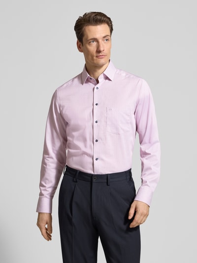 Męski model nosi Regular Fit Business-Hemd mit Kentkragen od OLYMP, czysta bawełna, krój regular fit, kieszeń na piersi, długość tyłu w rozmiarze 40: 70 cm, szerokość ramion w rozmiarze 40: 45 cm, długość rękawa w rozmiarze 40: 65 cm, jasnoróżowy, gładka tekstura, całkowity widok z przodu.